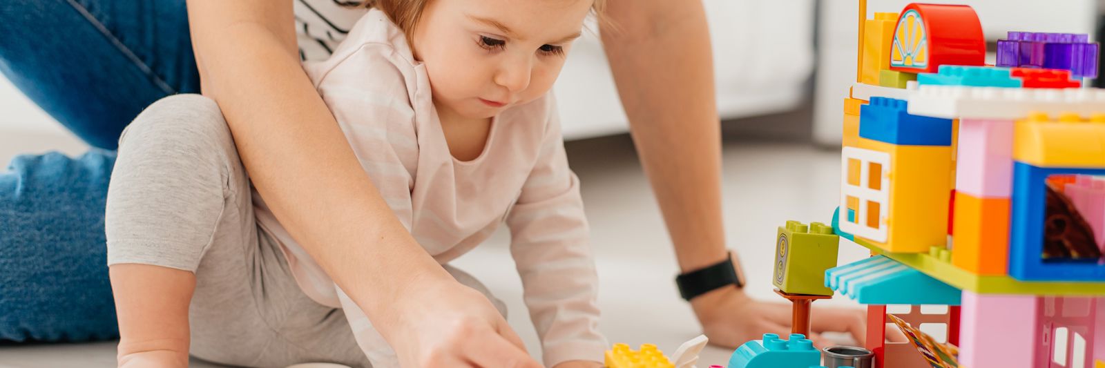 Voksen og barn leger med lego