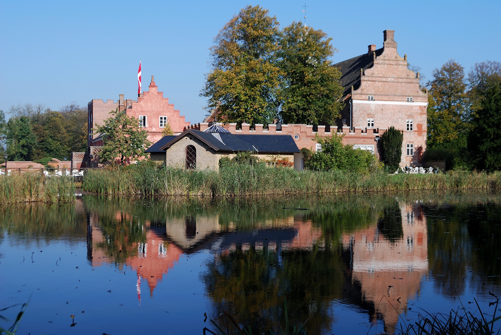 Broholm Slot og voldgraven i solskin